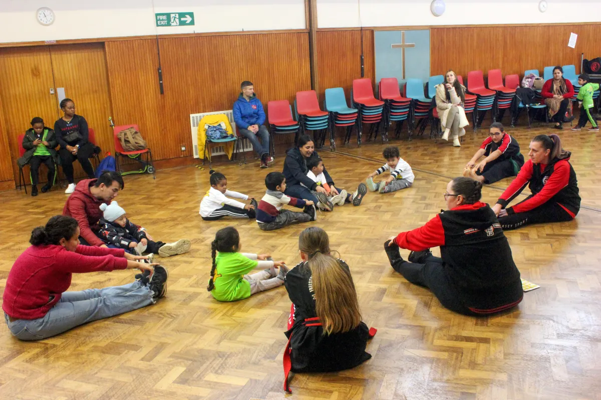 Group of Monster Tots & Their parents stretching at the end of class.