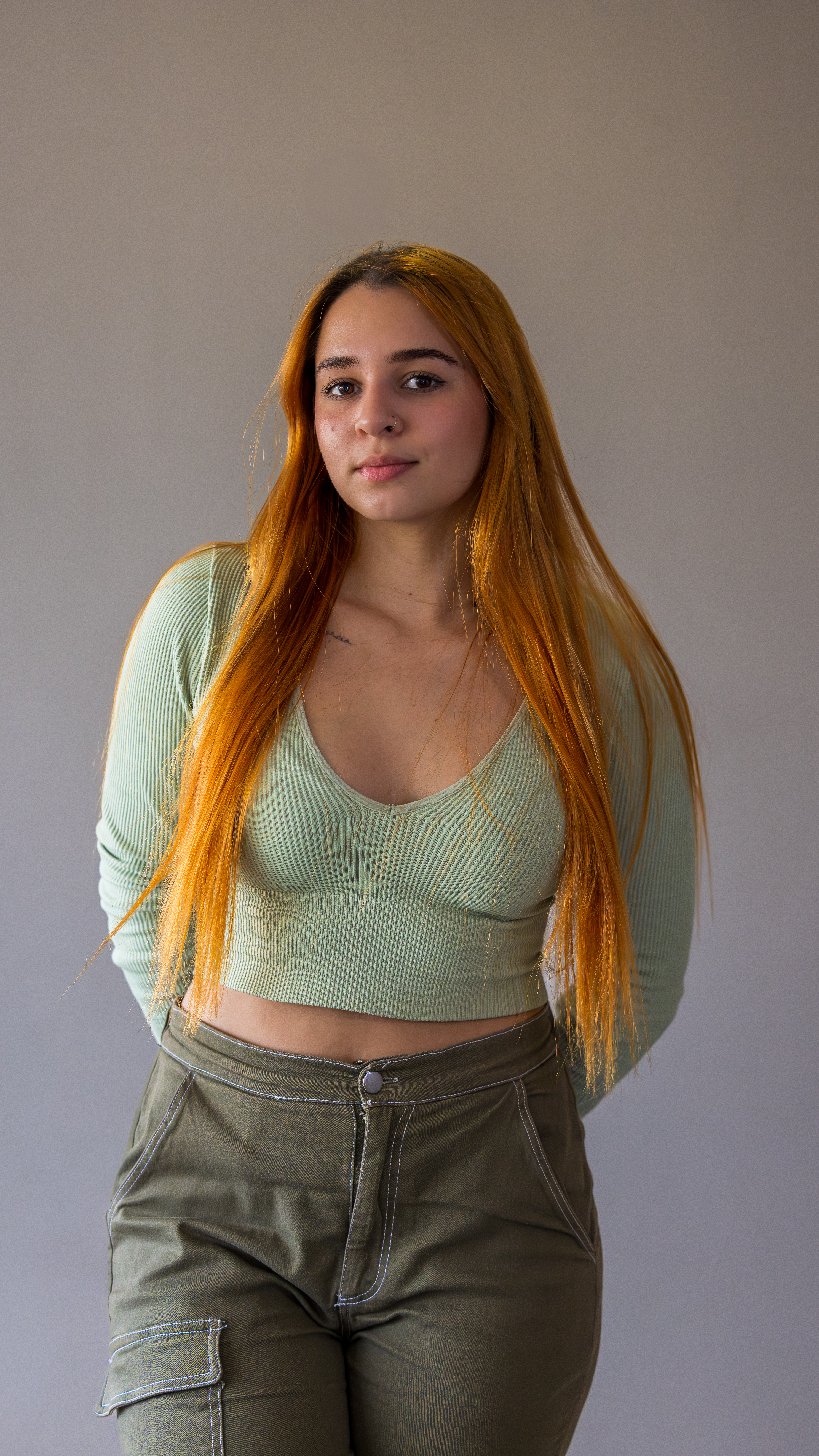 Woman standing in a relaxed pose wearing a white shirt and jeans during a portrait photo session