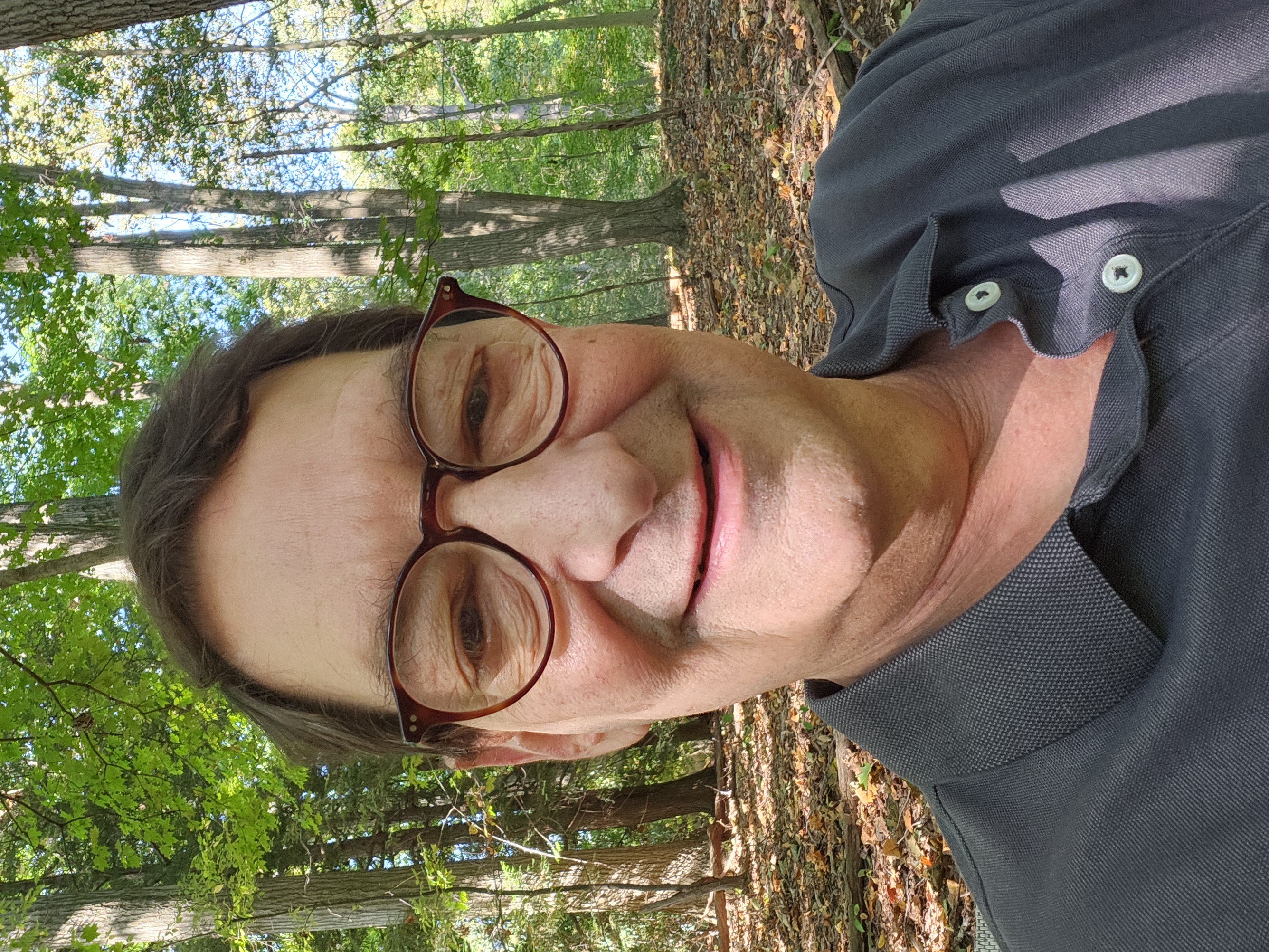 Professional portrait of Harry Krause, smiling, waist-up, neutral office background removed by soft overlay to create focus on face, warm natural lighting, photorealistic headshot.