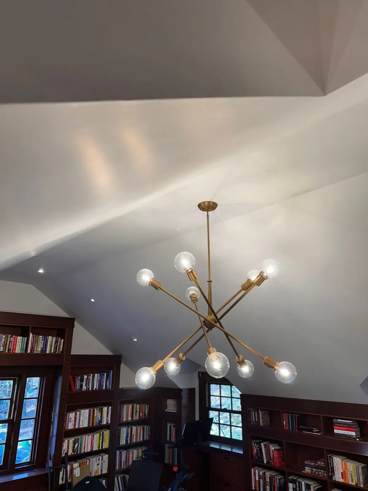 Modern chandelier lighting installation by Ryan Gath Electric inside a residential home office with bookshelves