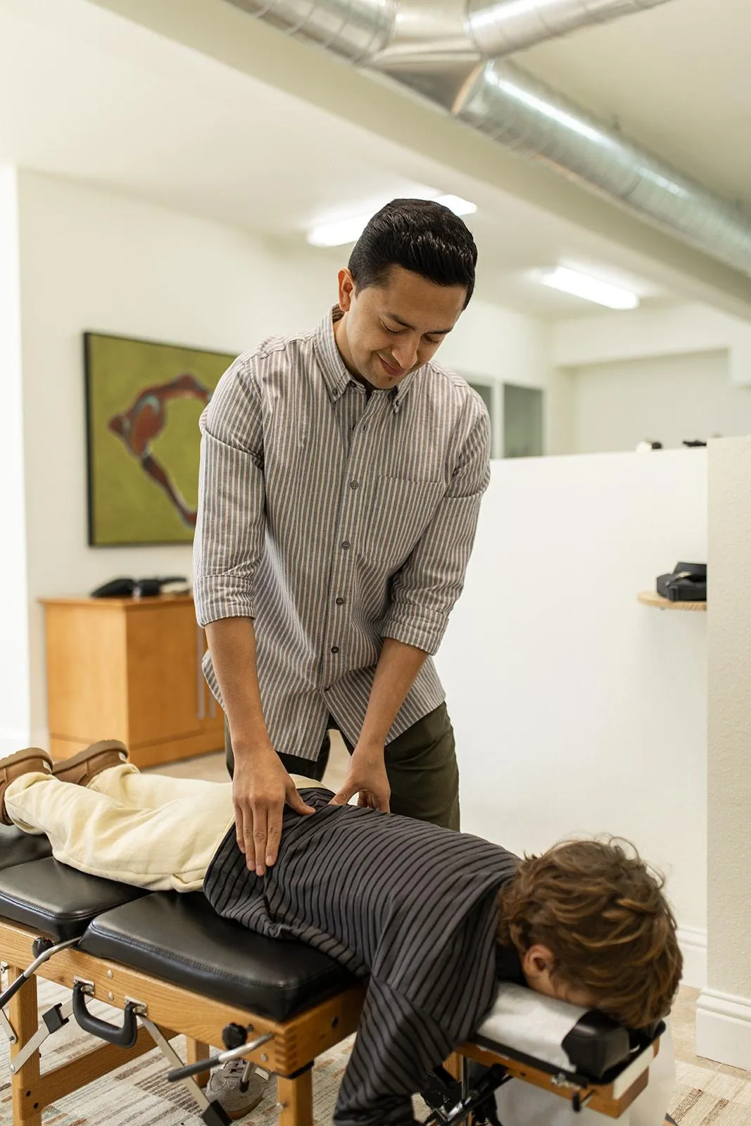 A soft, warm photo of a gentle consultation or instrument-assisted adjustment