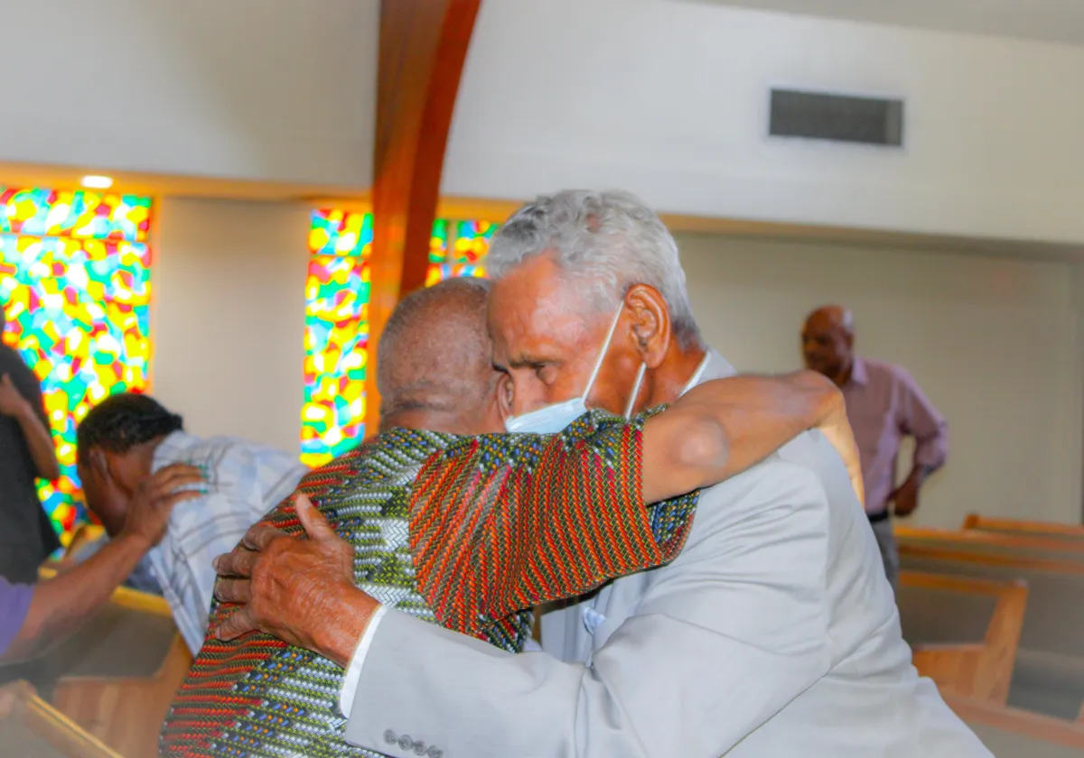 Warm embrace and comforting pastoral conversation in a welcoming community setting