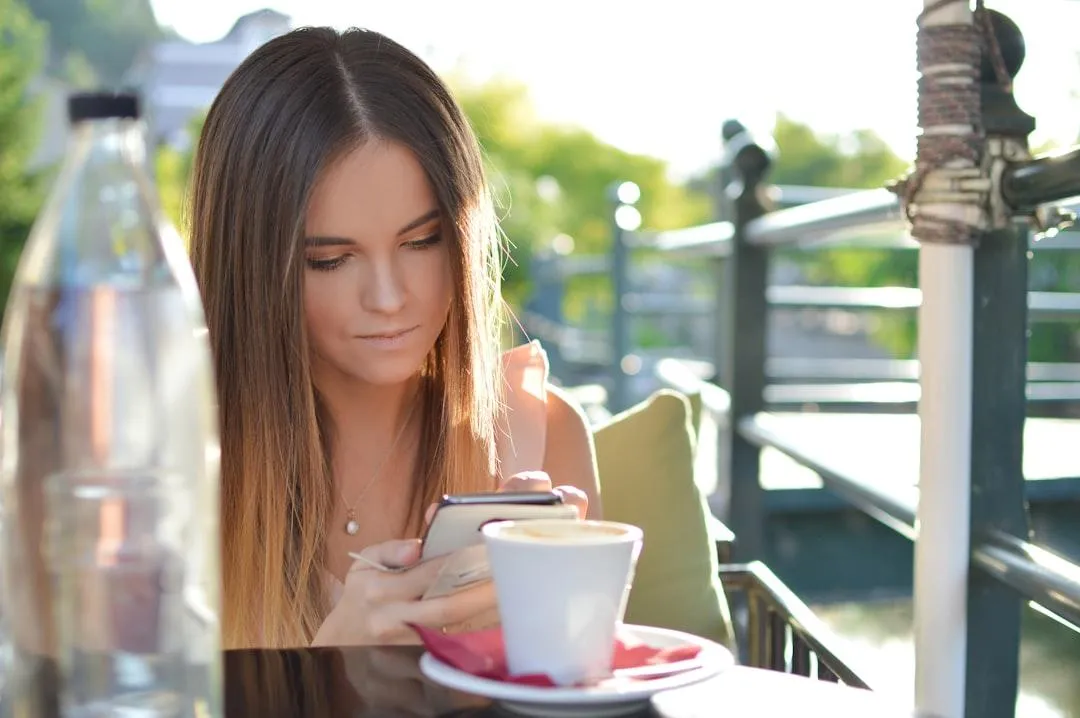 Woman on mobile sitting at cafe