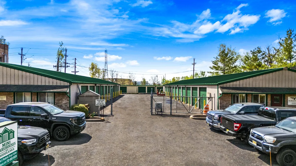a building with a grass roof and a body of water in the background