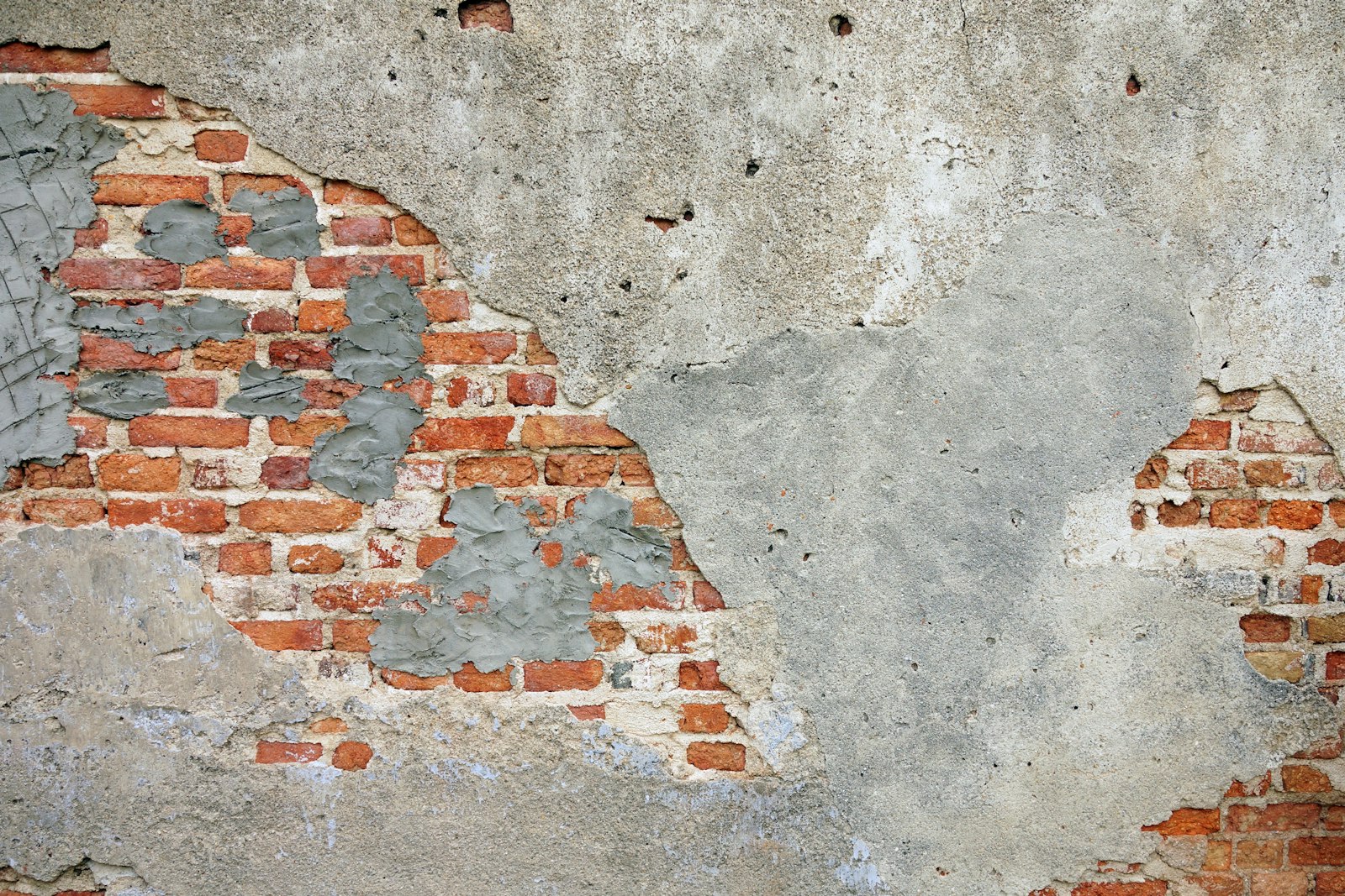 Weathered historic brick wall showing mismatched mortar patches, illustrating the challenge of matching century-old masonry