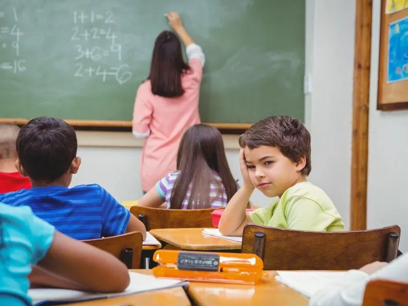 Father and two daughters laughing and playing together, covered in colourful paint, expressing playful family connection