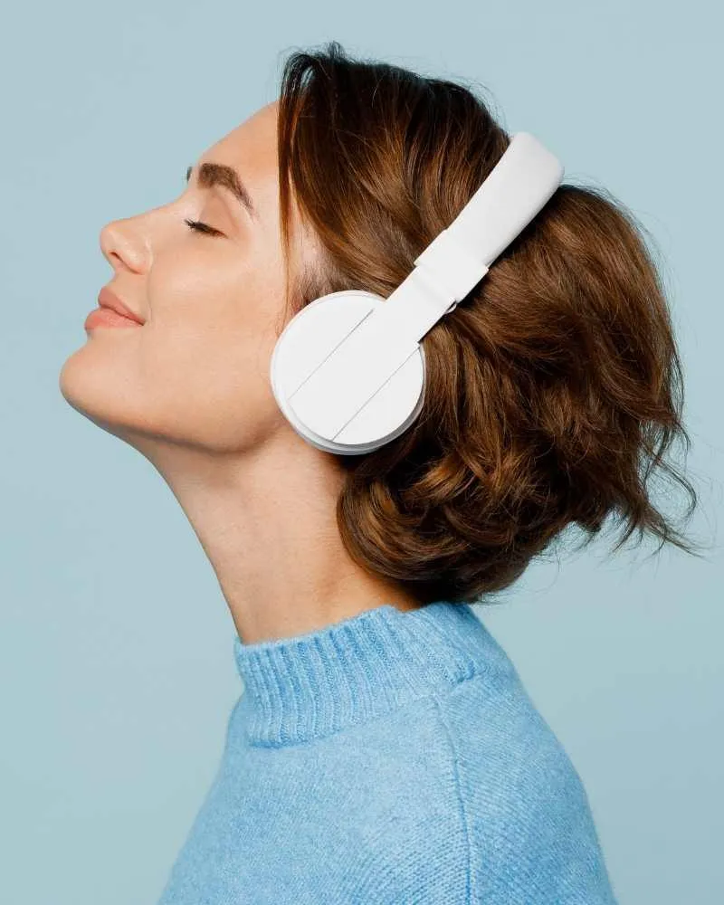 Person listening to filtered music through over-ear headphones during a Safe and Sound Protocol session, supporting regulation and focus.