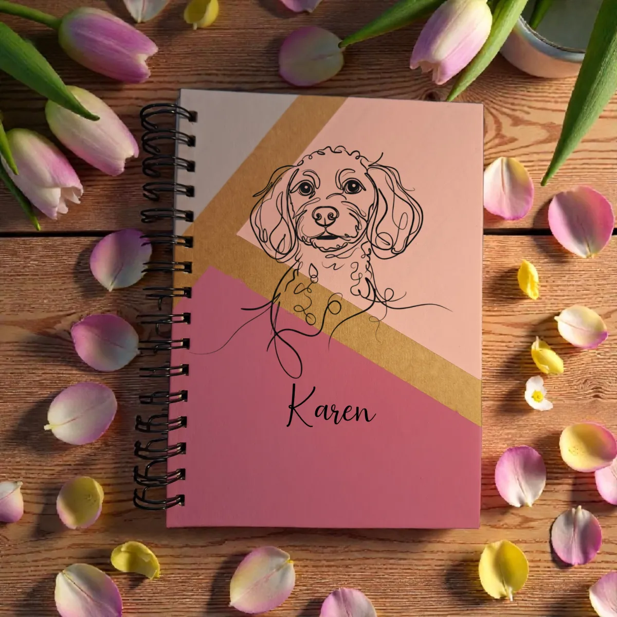 A picture of a notebook with a dog on the cover on pink petals