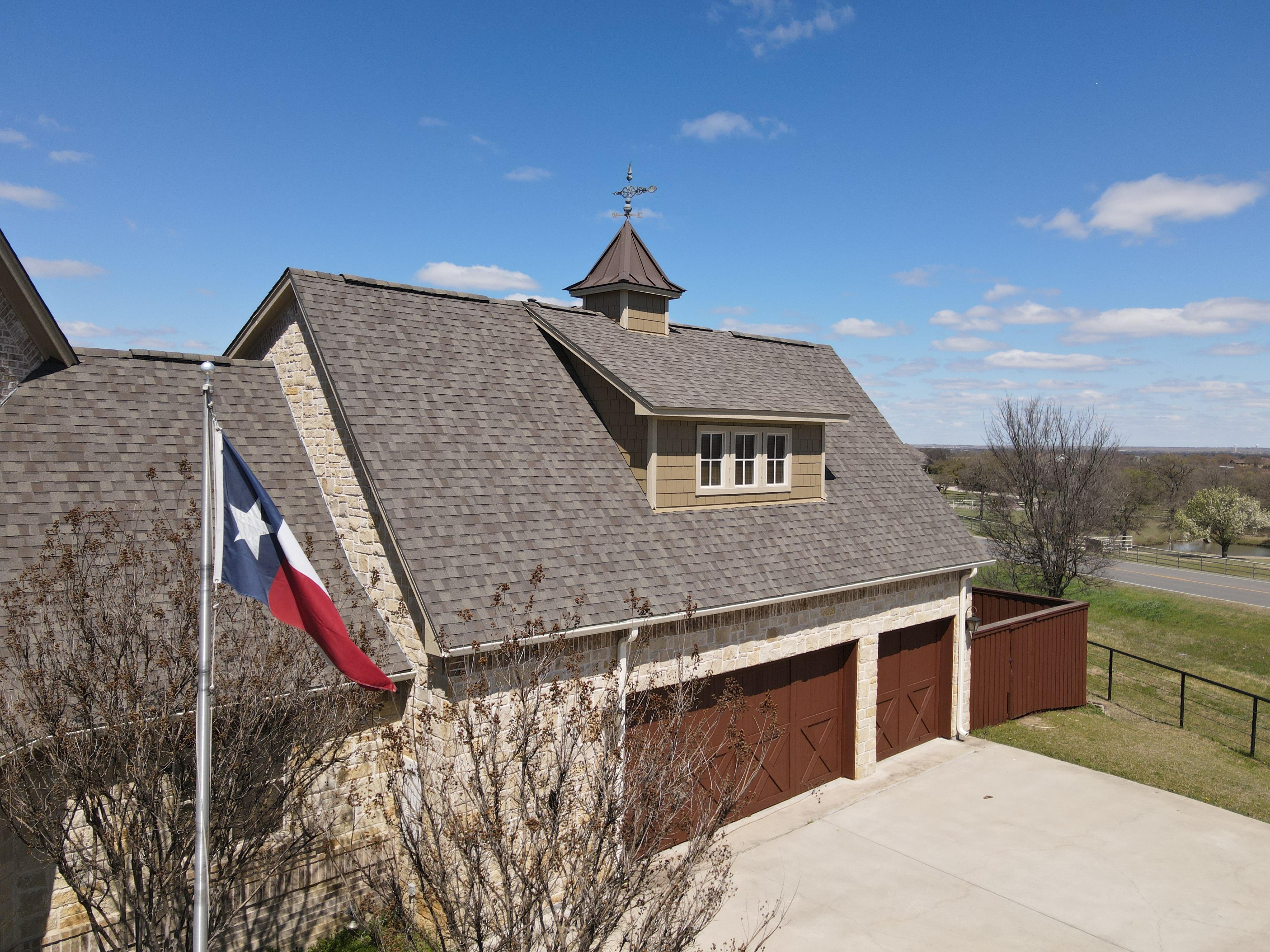 A house is partially obscured by trees and bushes.