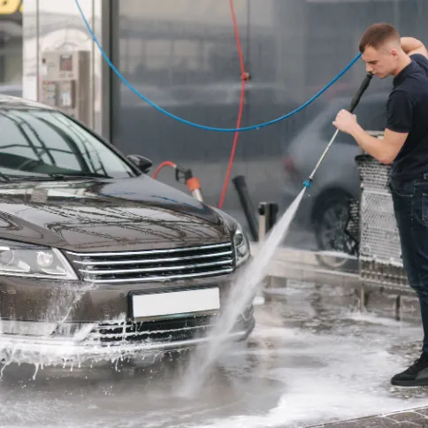 Man washing a car in a parking lot