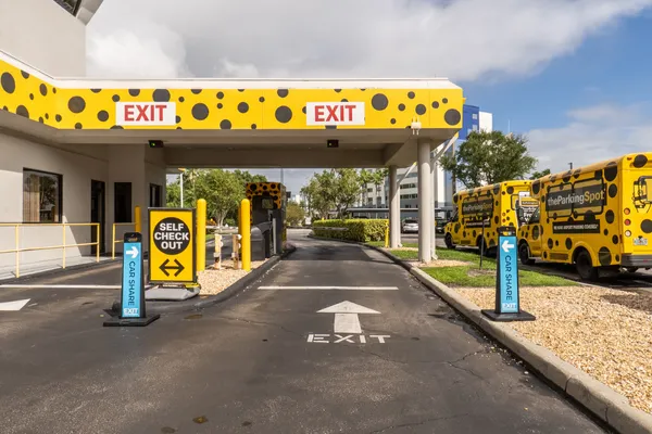 Person boarding a bus at the airport, carrying luggage.