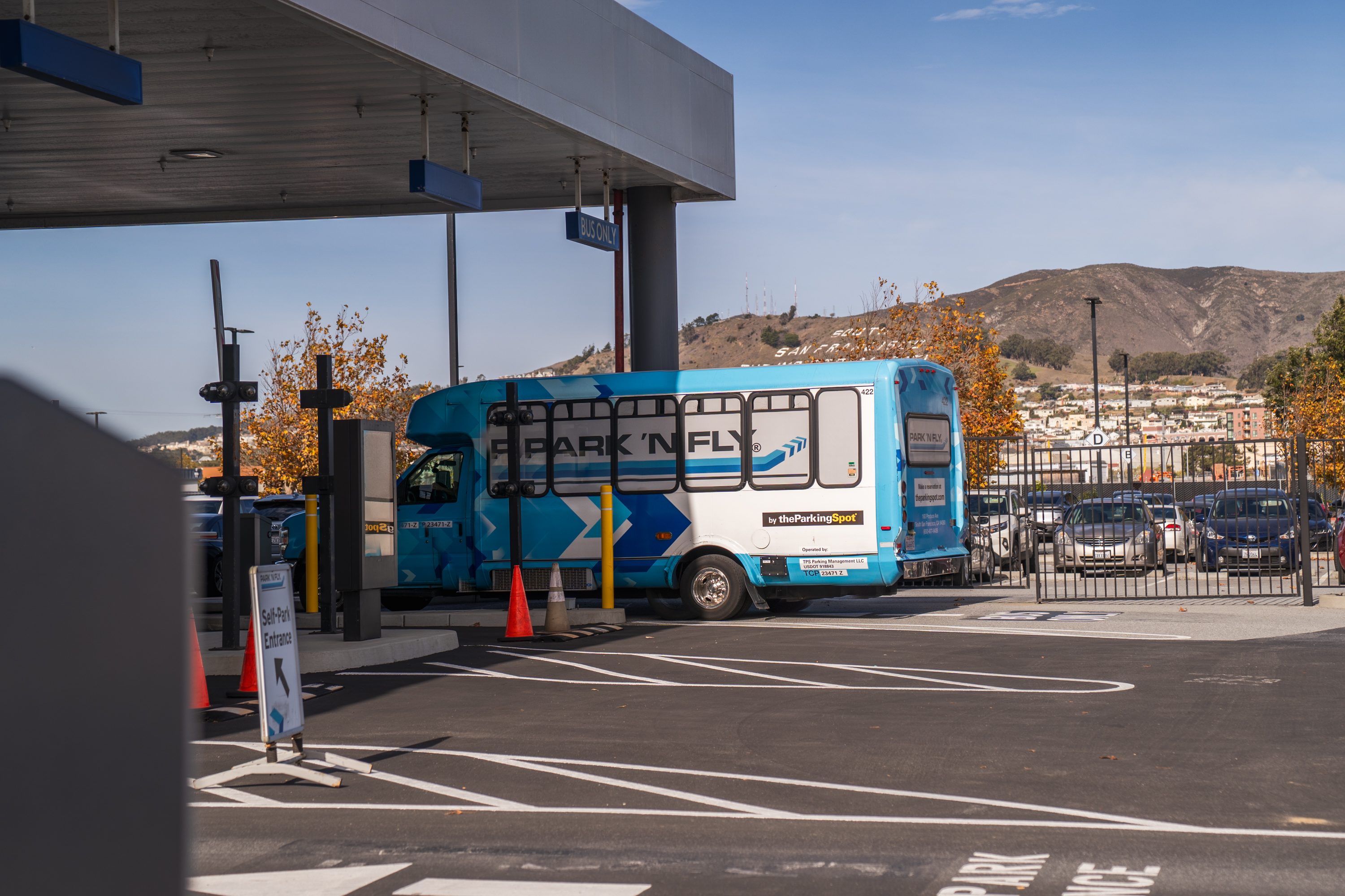 Person boarding a bus at the airport, carrying luggage.