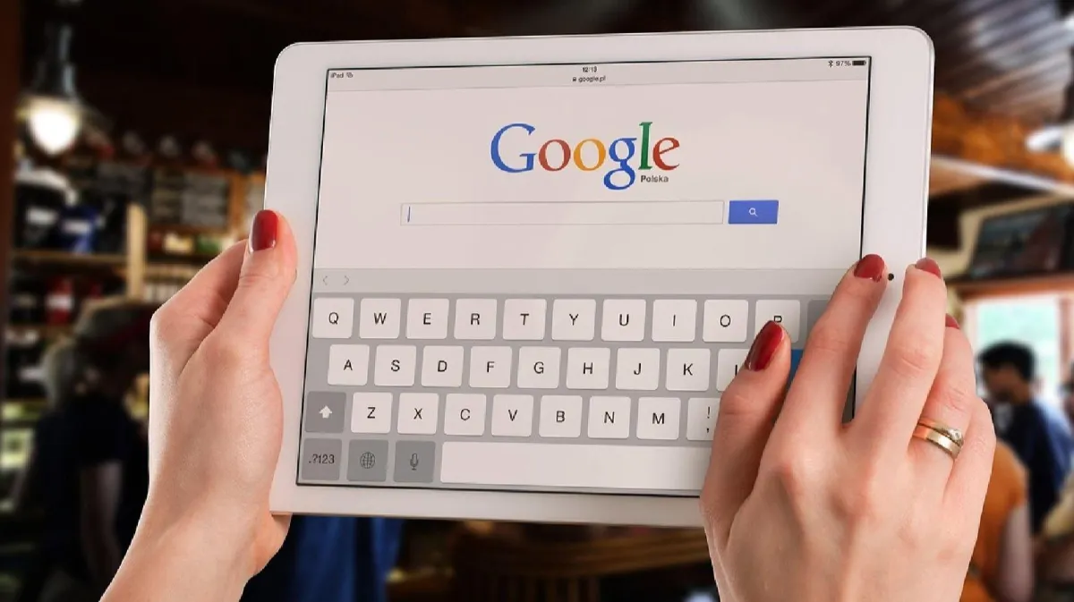 Person using a tablet to search on Google, illustrating how customers find businesses through online search.