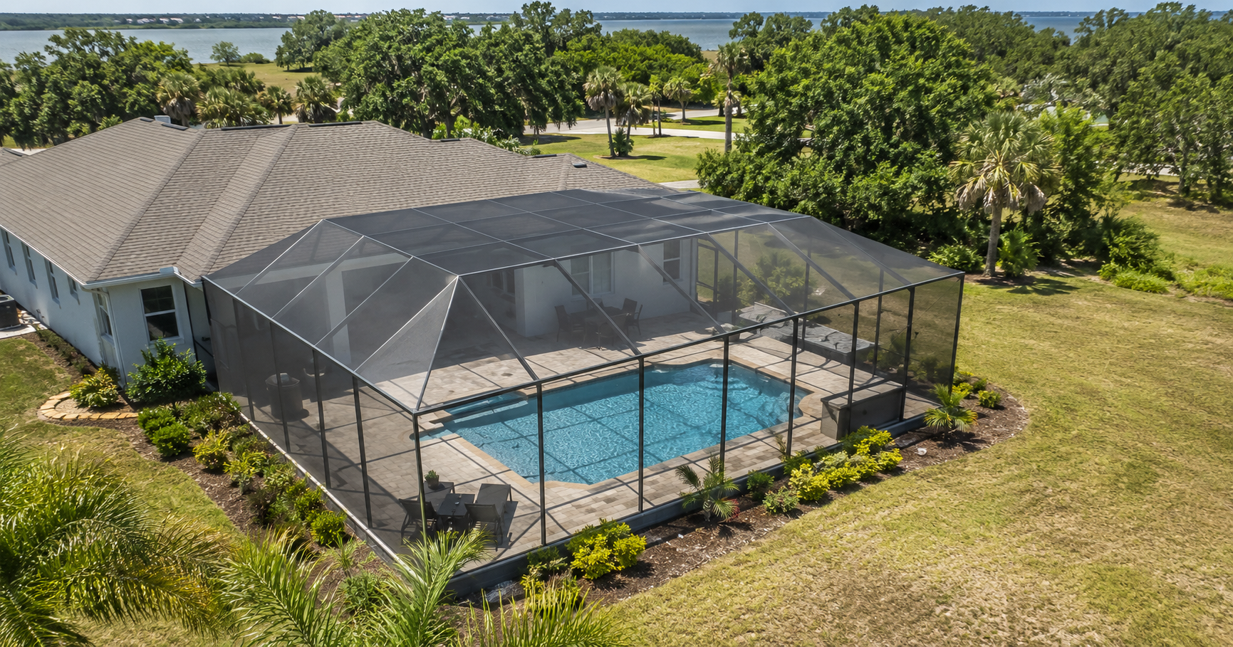Aerial view of a Destin, Florida home with a screened pool enclosure, illustrating the scale of a typical Emerald Coast pool enclosure project.