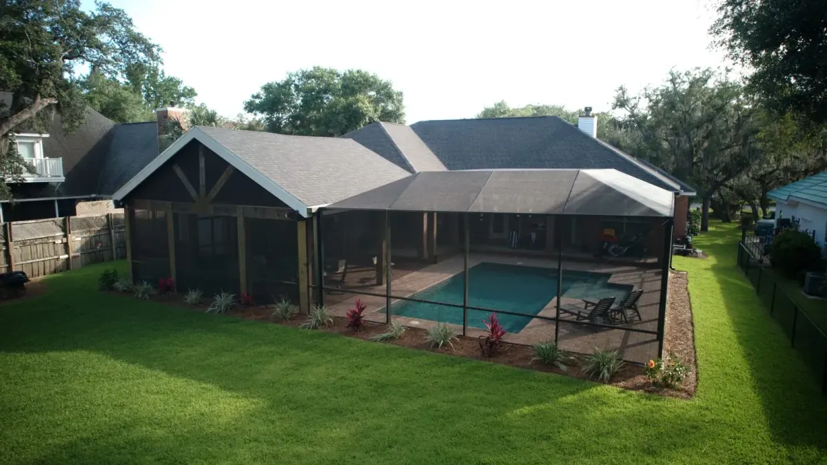 Bronze mansard pool enclosure beside a covered gable porch, built from its approved 3D model by Aluminum Building Systems in Destin, FL