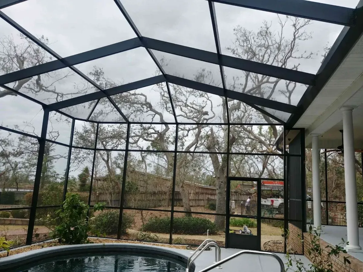 Interior of a bronze lazy hip pool enclosure with hip ends sloping to the screen walls, built by Aluminum Building Systems in Callaway, FL