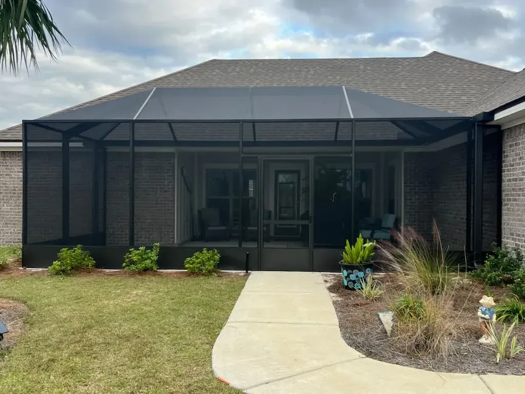 Bronze lazy hip screen enclosure over the front patio of a single-story home, built by Aluminum Building Systems in DeFuniak Springs, FL