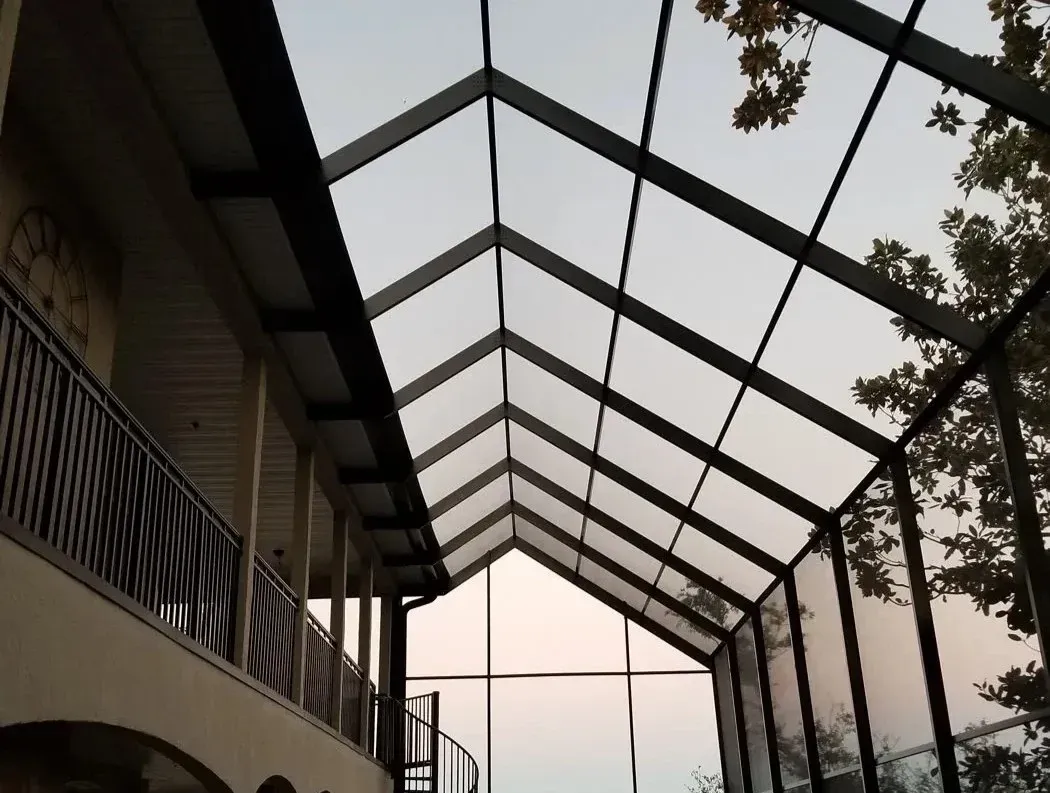 Bronze transverse gable enclosure on a two-story home framing a wooded view, built by Aluminum Building Systems in Fort Walton Beach, FL