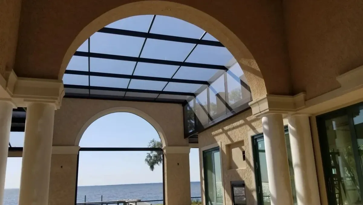 Bronze multi-level screen enclosure over a waterfront loggia with arched openings, built by Aluminum Building Systems in Gulf Breeze, FL