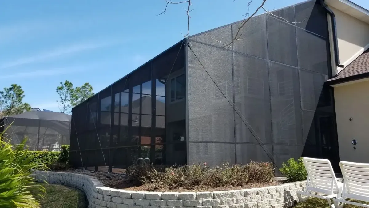 Bronze mono-slope screen enclosure running off a two-story wall, custom built by Aluminum Building Systems in Mary Esther, FL