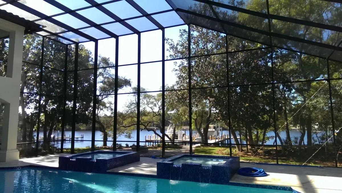 Bronze custom pool enclosure with two-story screen walls on the water, built by Aluminum Building Systems in Lynn Haven, FL
