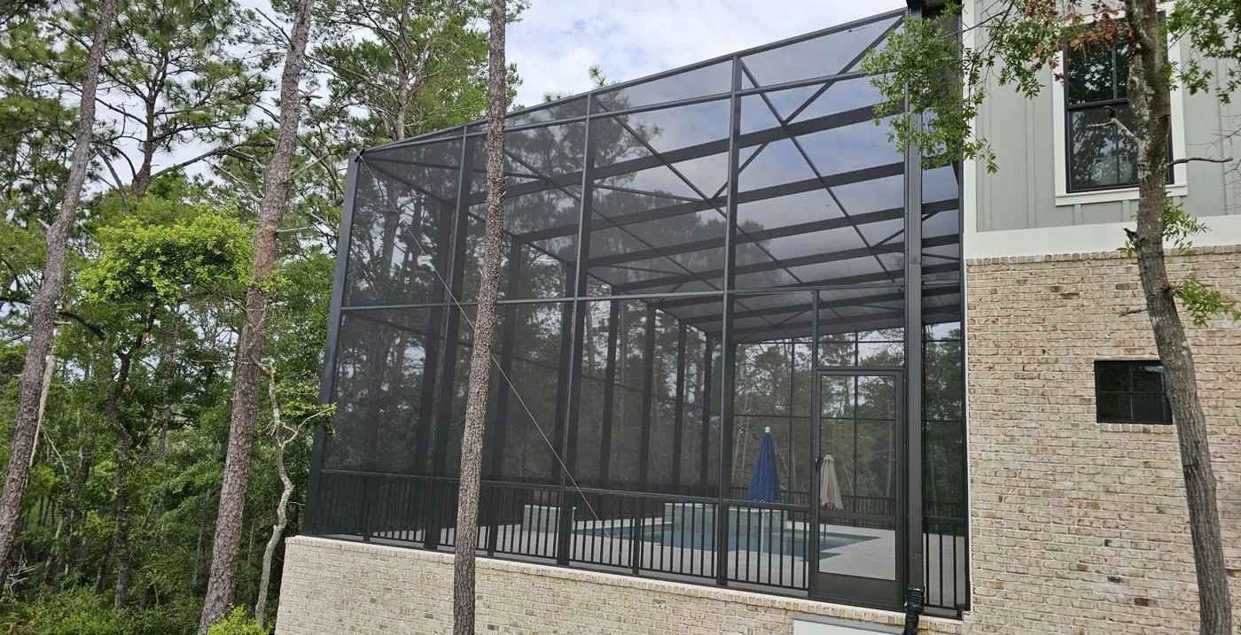 Finished bronze mono-slope enclosure off a two-story home, built from its 3D model by Aluminum Building Systems in Freeport, FL