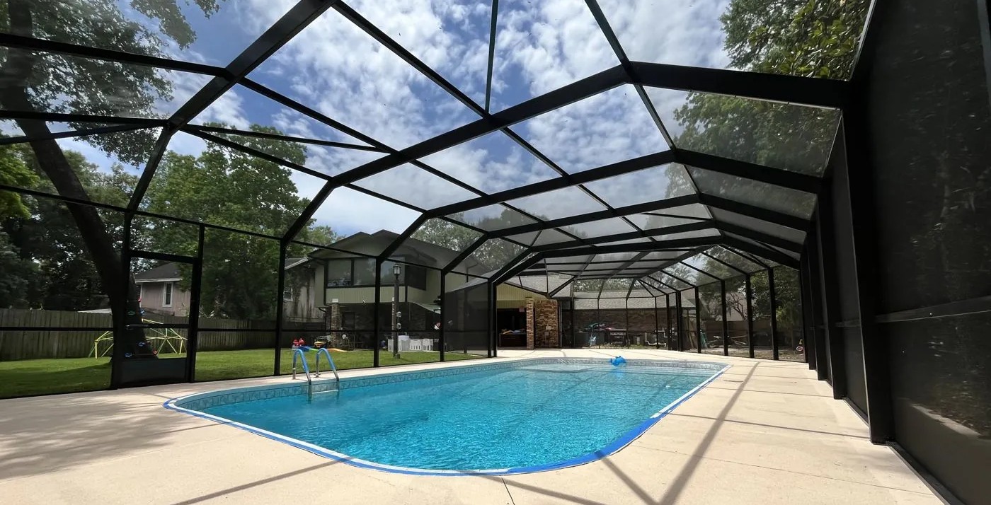 Finished bronze custom roofline pool enclosure over a freeform pool, built by Aluminum Building Systems in Miramar Beach, FL