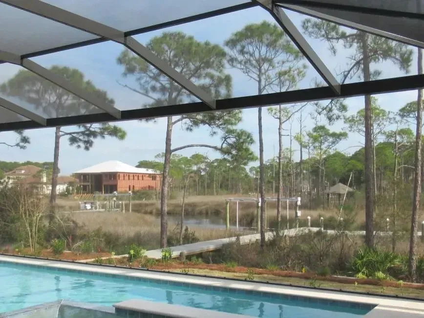 Infinity View enclosure beam spanning over a pool with an open marsh view, built by Aluminum Building Systems in Shalimar, FL