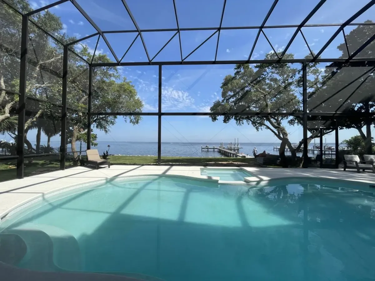 Infinity View pool enclosure with a clear span facing the bay and no interior posts, built by Aluminum Building Systems in Niceville, FL