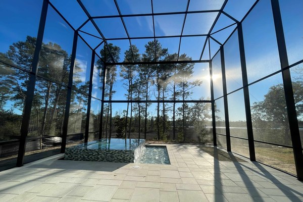 Infinity View screen pool enclosure with raised spa in the Florida Panhandle, built by Aluminum Building Systems