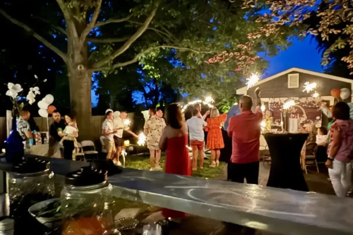 Bars on Wheels guests celebrating with sparklers at outdoor private party with mobile bar service