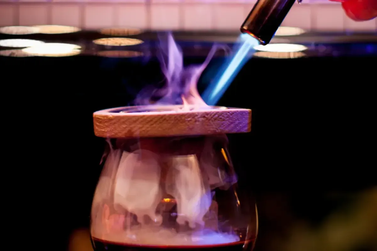 Bars on Wheels bartender crafting smoked cocktail with flame at upscale private event bar set