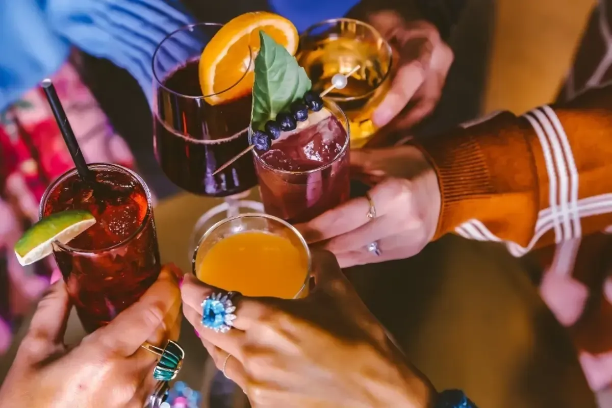 Bars on Wheels guests toasting colorful cocktails at lively private party with mobile bar service