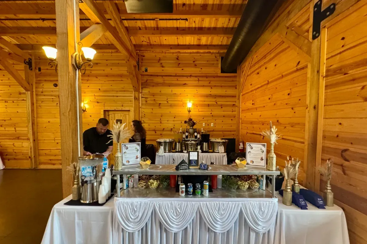 Bars on Wheels indoor mobile bar setup with drink station at rustic wedding reception venue