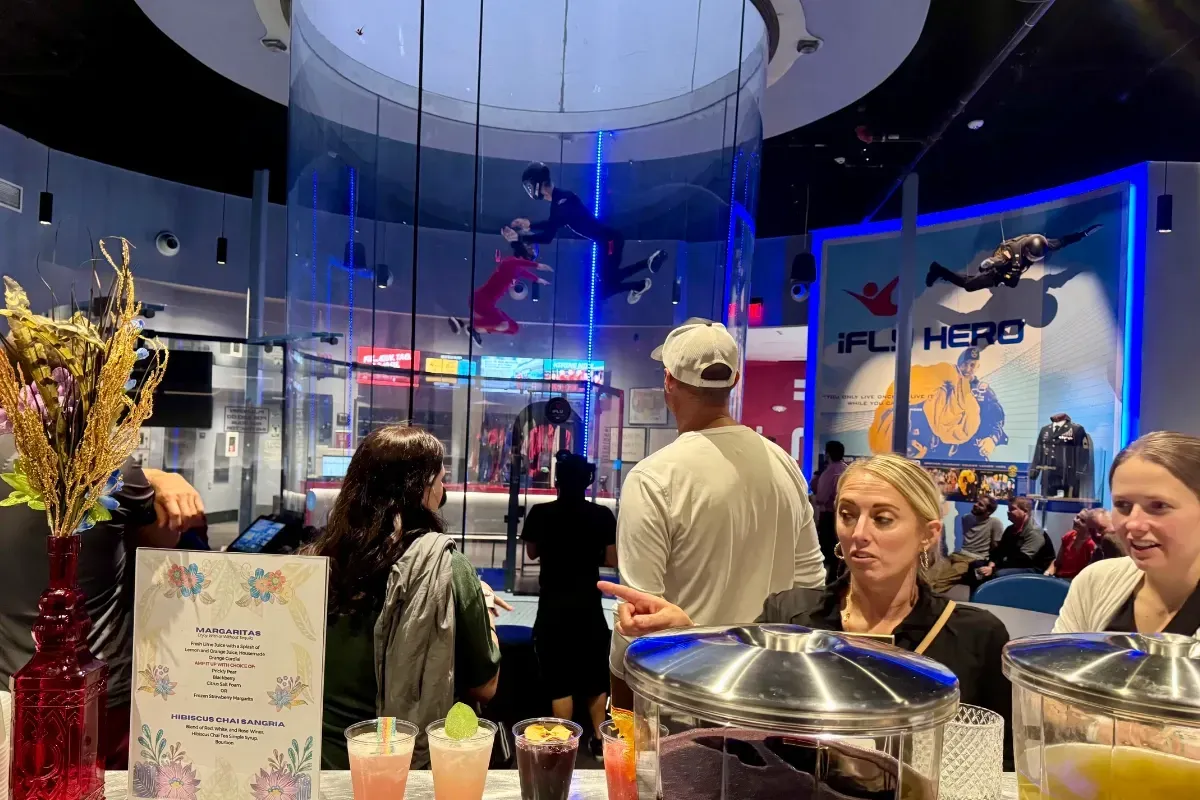 Bars on Wheels drink station serving cocktails at lively corporate event with entertainment venue atmosphere
