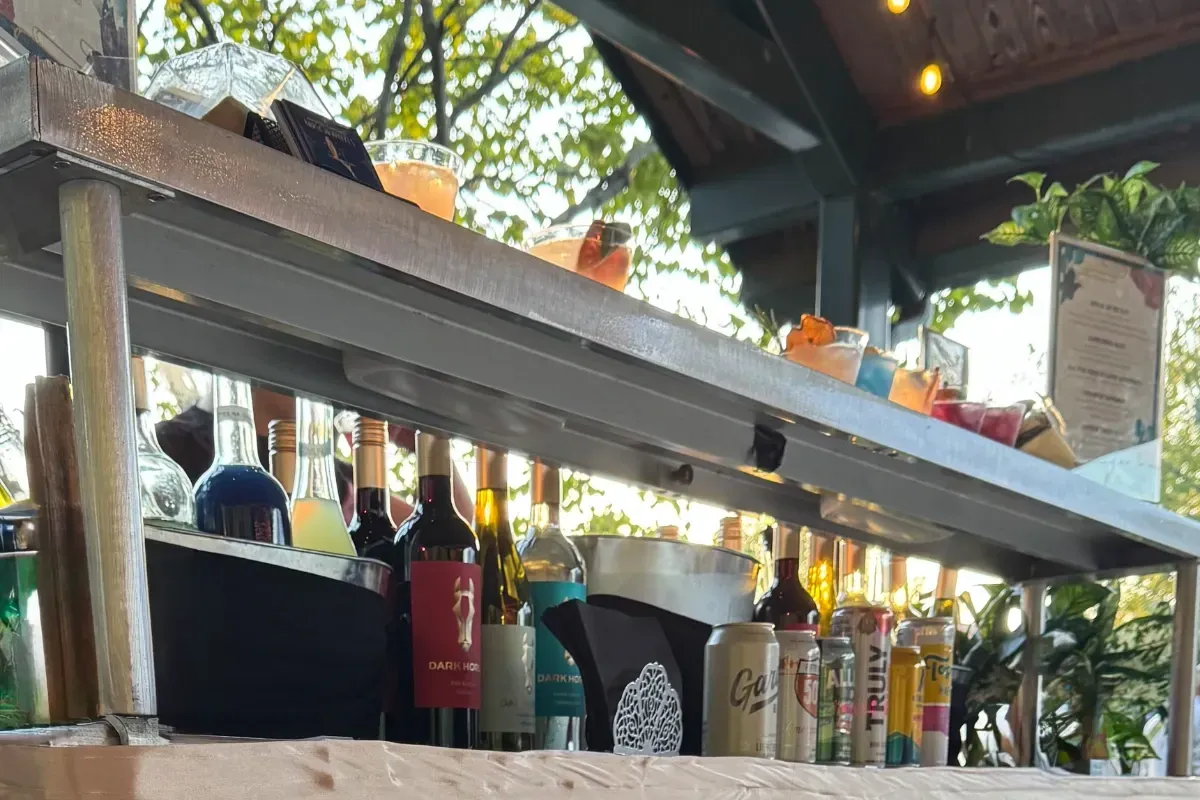 Bars on Wheels mobile bar setup with assorted drinks and cocktails at outdoor private party event