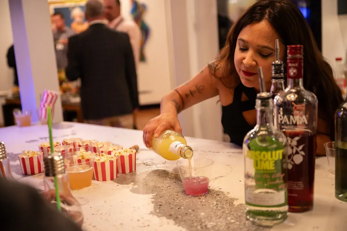 Bars on Wheels bartender pouring cocktail drinks at lively private party mobile bar setup
