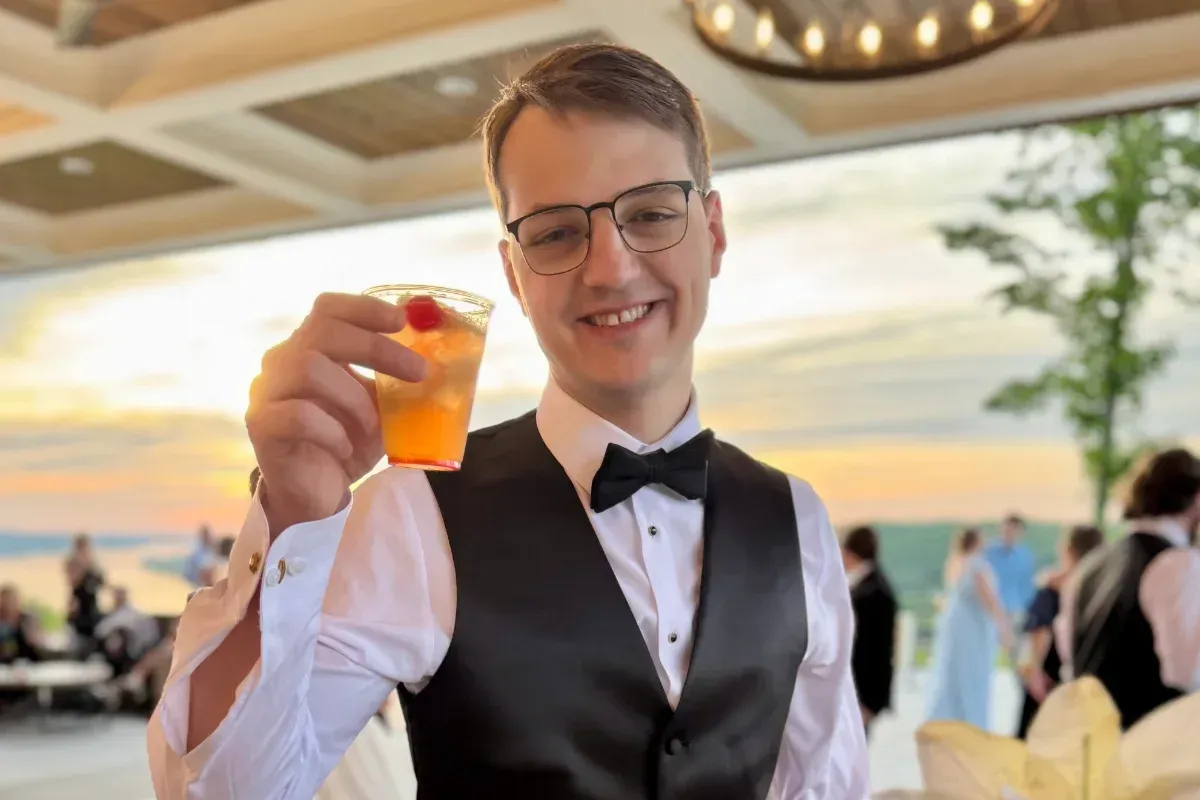 Bars on Wheels wedding guest holding cocktail at outdoor reception with mobile bar s