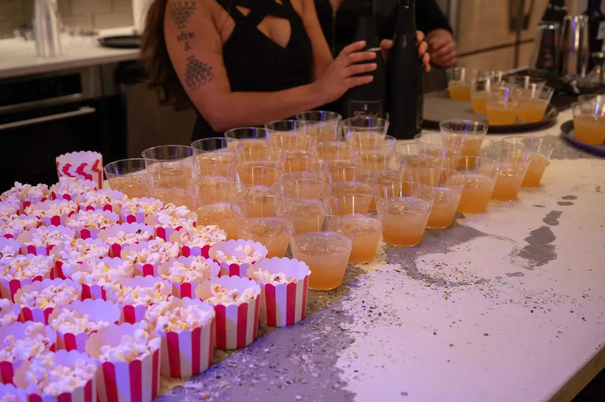 Bars on Wheels preparing multiple cocktails for guests at a catered event with drink setup