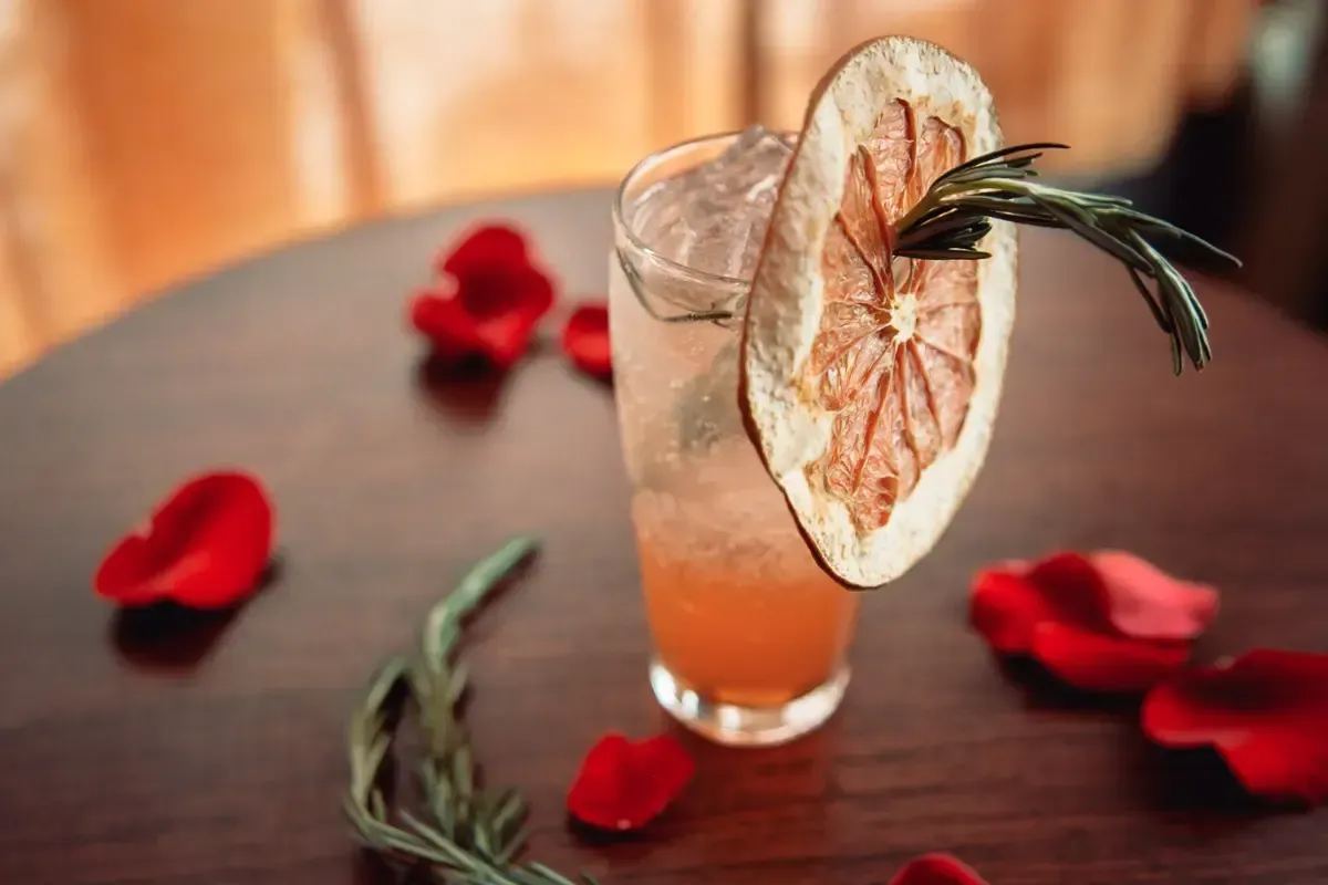 Bars on Wheels cocktail with dried citrus garnish and rosemary on a styled table
