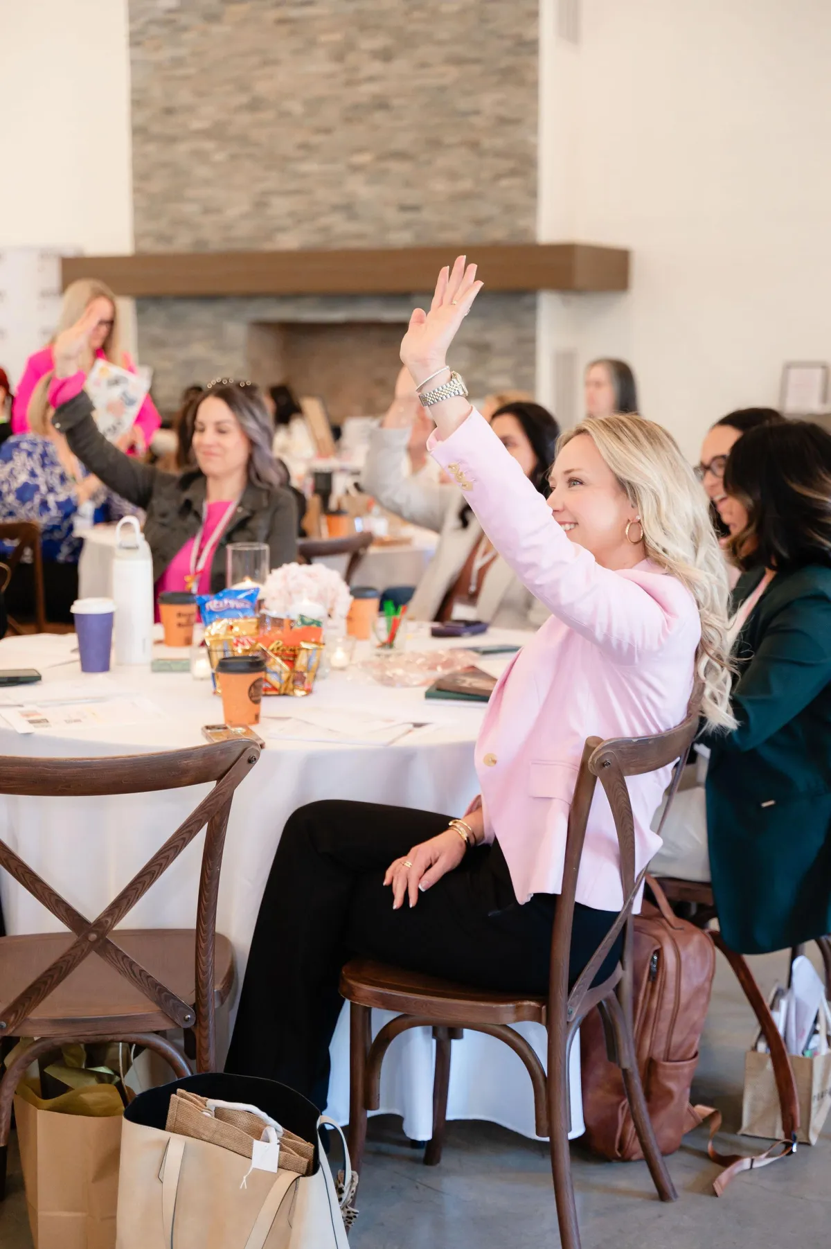 woman working on laptop sitting on bed floor with shoes off.