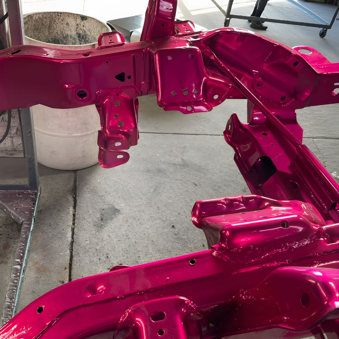 A close-up shot of a complex frame component, painted in the same glossy hot pink as the first image.