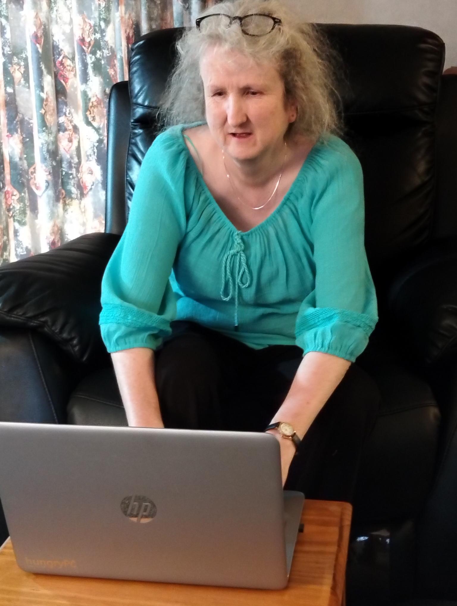 short-haired black cat besides brown wooden table