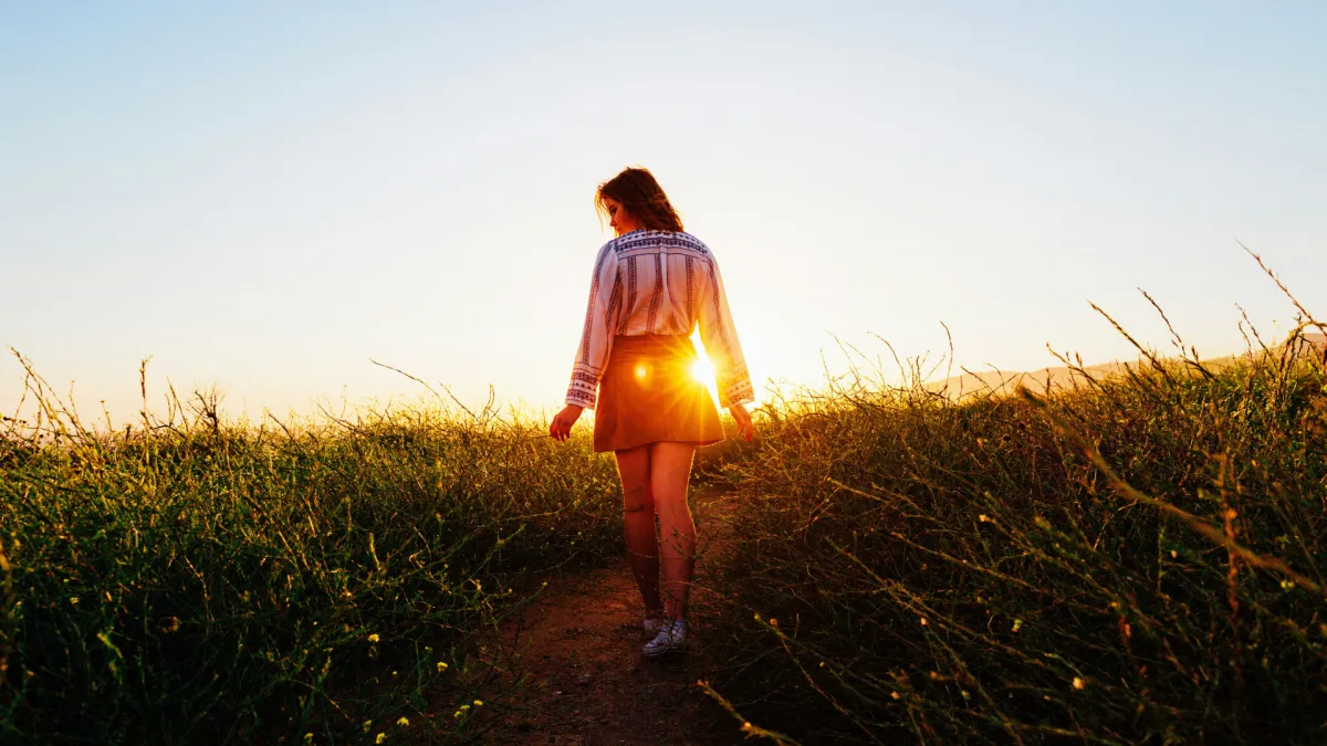 woman looking outward or stepping forward, warm tones, editorial quality