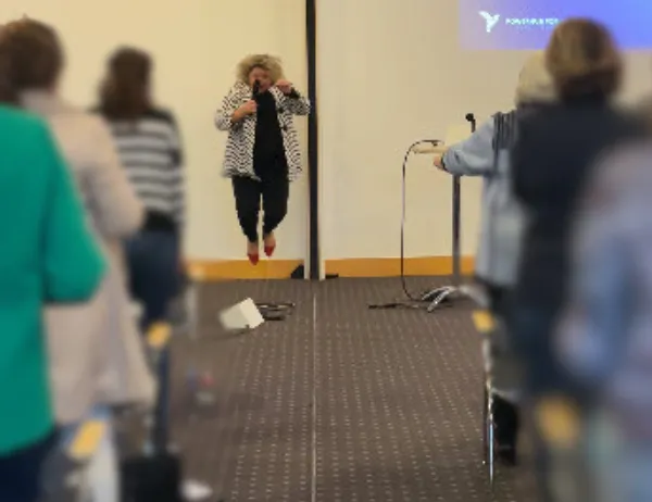  Birgit Gosejacob presenting on stage — dynamic gesture, full energy