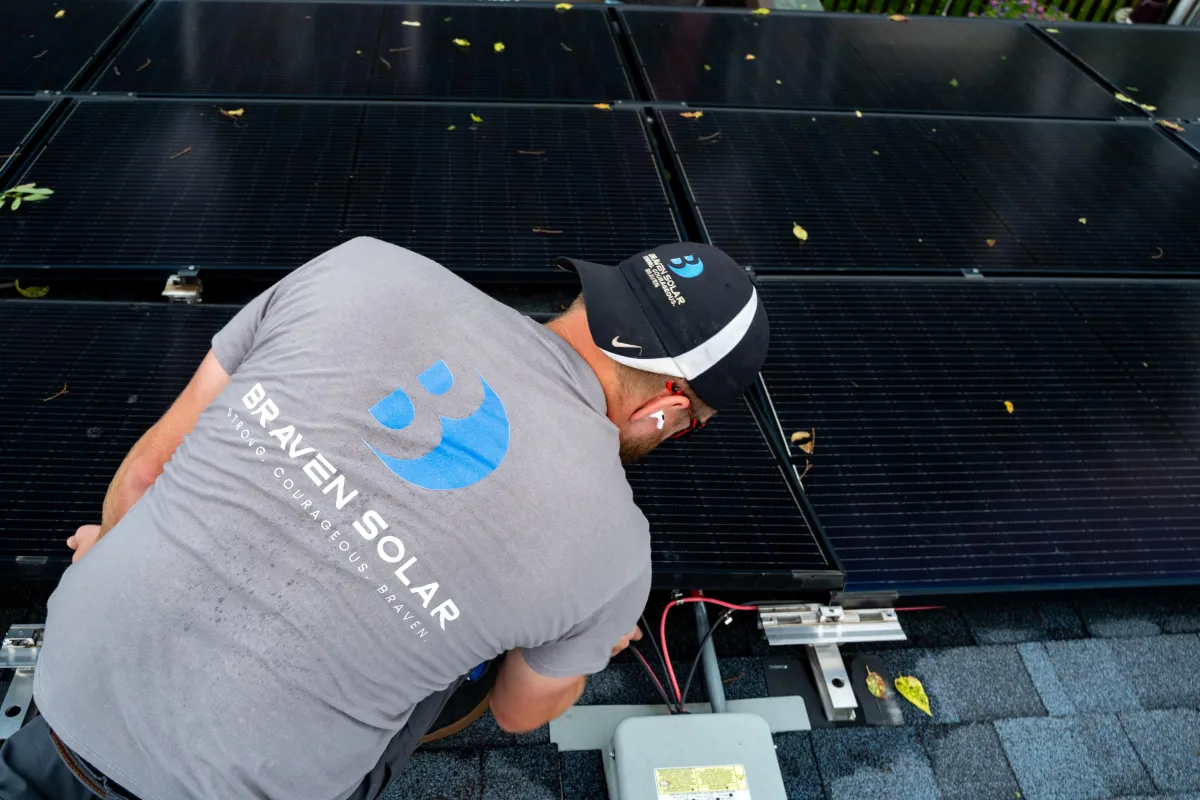 black solar panels on green grass field under blue sky during daytime