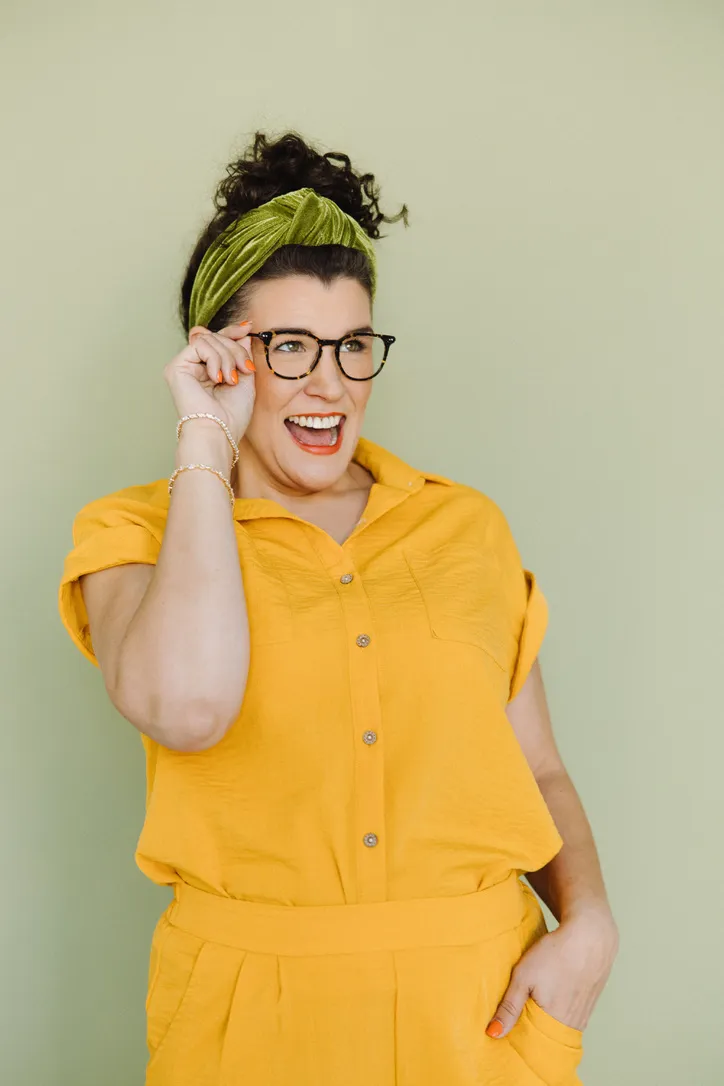 Jackie Reynolds, founder of The Selfhood Studio, laughing in a yellow shirt