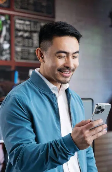 man smiling and looking at his phone
