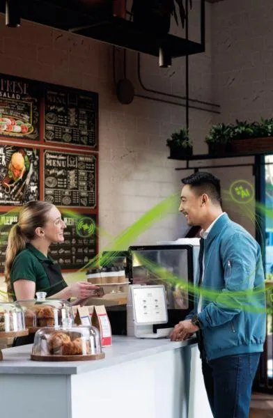 man talking to barista at a coffee shop