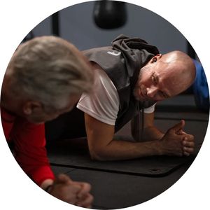 man helping another man do a plank